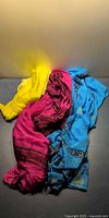Three silk scarves arranged together showing colors yellow, fuchsia, blue
