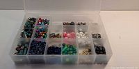 Full view of organizer showing 15 compartments filled with assorted beads
