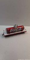 Side view of Bachmann Coca-Cola tank car on flatcar