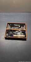 Open wooden box showing full set of tools in fitted tray