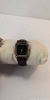 Front view of Cardinal rectangular wristwatch, black dial, gold-tone case