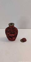 Full view of cinnabar snuff bottle with detached lid
