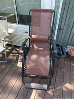 Full view of brown mesh zero-gravity recliner on deck