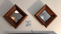 Front view of both matching square wood-framed mirrors hung on wall