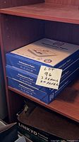Three sealed blue HP Multipurpose Paper reams on shelf