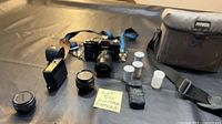 Entire lot laid out showing camera with lens, extra lens, flash, film canisters, strap, bag