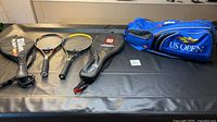 Full view showing two racquets, cover and blue US Open bag