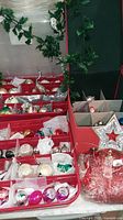 Storage case open showing multiple vintage ornaments in compartments and star topper