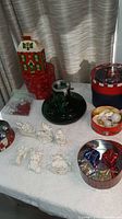 Lot overview showing tree stand, ornaments, tins, boxes, bead garland