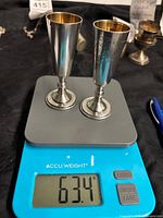Both 875 silver shot glasses on scale showing 63.4 g