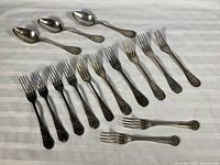 Full view of 4 spoons, 12 dinner forks, 2 additional forks
