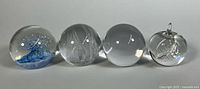 Group of four spherical paperweights side by side