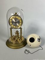 Panasonic R-70 radio beside brass glass-domed mantel clock