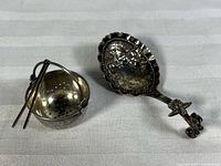 Monkey spoon and miniature strainer side by side