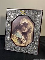 Front view of ornate sterling silver photo frame with inserted portrait