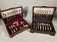 Two wooden flatware chests open showing full contents