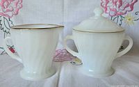 Front view of creamer and covered sugar bowl