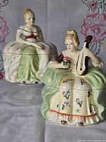 Both porcelain Victorian lady trinket boxes showing size and details