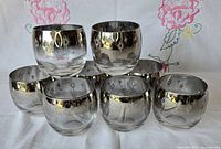 Stacked view showing eight roly poly glasses with silver fade and starburst pattern