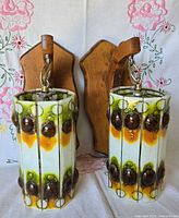 Front view of both sconces showing glass shades and wooden mounts