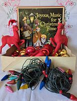 Lot overview showing deer figurines, vinyl record set, ornaments tray and string lights