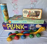 All items grouped: KerPlunk, Lippy the Lion, Western Express train, jigsaw puzzle tube, wooden pull toy