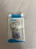 Front of opened retail pouch showing metal flash drive with keyring