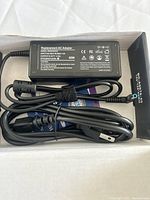 Adapter and cord inside box showing label, connector, and packaging