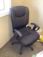 Front angle of high-back office chair showing upholstery and armrests