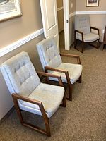 Three grey fabric chairs with oak frames lined in hallway