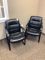 Front view of both black bonded leather guest chairs