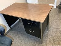 Front angled view showing wood-grain top, pedestal drawers, and metal legs