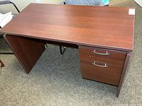 Full view of desk front showing finished side, open knee space and drawer pedestal