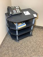 Full view of four-tier shelf with phone on top