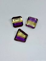 Three square synthetic ametrine gemstones purple-yellow bi-colour