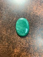 Front view of polished green aventurine cabochon on background