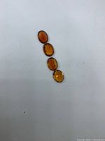 Four oval amber-yellow citrines on white background