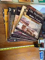 Stack of 11 Walter T. Foster art books with measuring tape for scale
