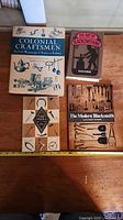 Four blacksmithing and tool history books on table