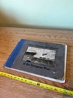 Front cover showing title, photo plate and tape-reinforced spine with measuring tape for scale