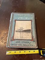 Front cover showing title, ship image, measuring tape for scale