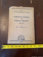 Front cover of dust-jacketed book with title and measuring tape