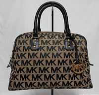 Front view of Michael Kors Bedford MK Signature satchel handbag showing MK monogram, handles, charm
