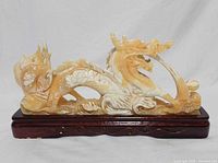 Front view of yellow jade dragon on wooden stand