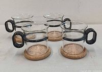 All four glass mugs on cork coasters, front angle