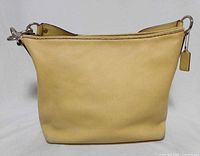 Front view of yellow leather Coach hobo handbag showing shape and hardware