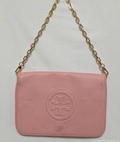 Full view front of pink Tory Burch leather clutch with chain strap