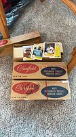 Two cardboard cheese boxes and open carton filled with baseball cards