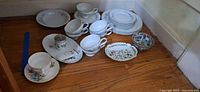 Assorted china items grouped on floor showing overall quantity