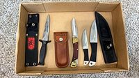 All four knives and three sheaths arranged in box